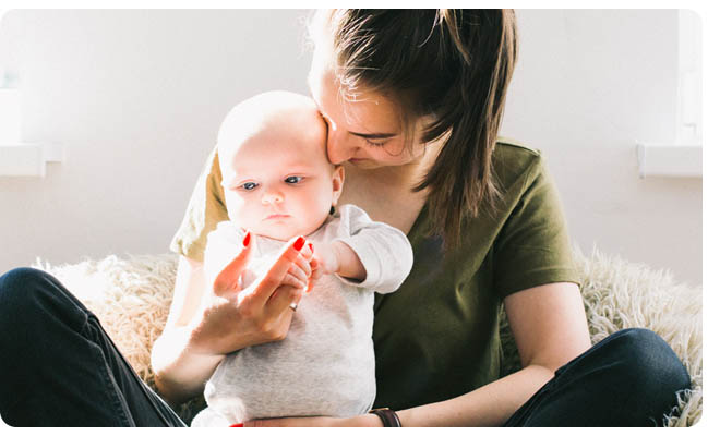 Woman holding a baby in her lap.