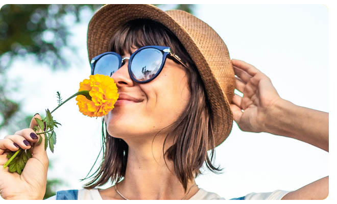 Woman holding a flower to her nose